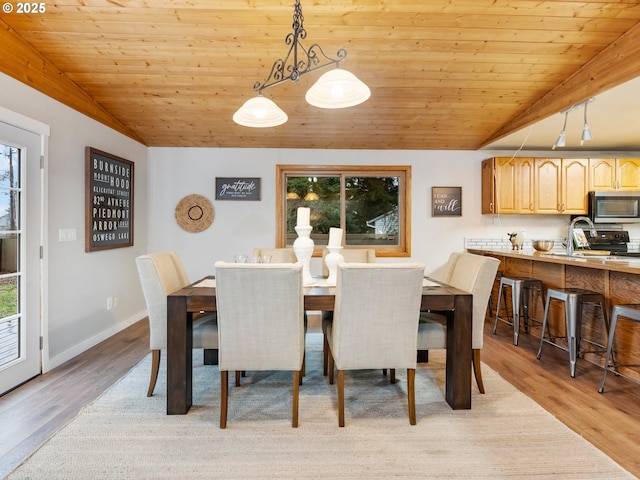 dining area featuring lofted ceiling, light hardwood / wood-style floors, and wooden ceiling