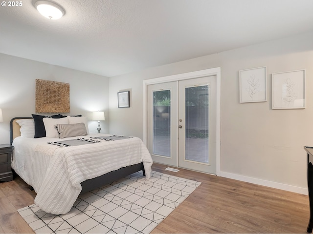 bedroom featuring french doors, access to outside, and light hardwood / wood-style flooring