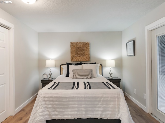 bedroom with hardwood / wood-style floors and a textured ceiling