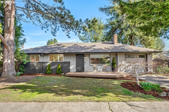 ranch-style house featuring a garage, a chimney, and a front yard