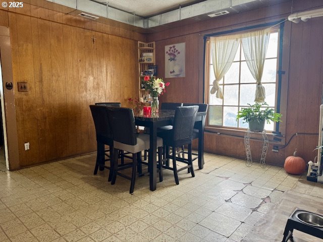 dining space featuring wood walls