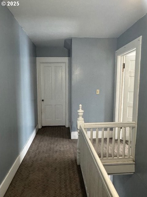 hall with dark colored carpet