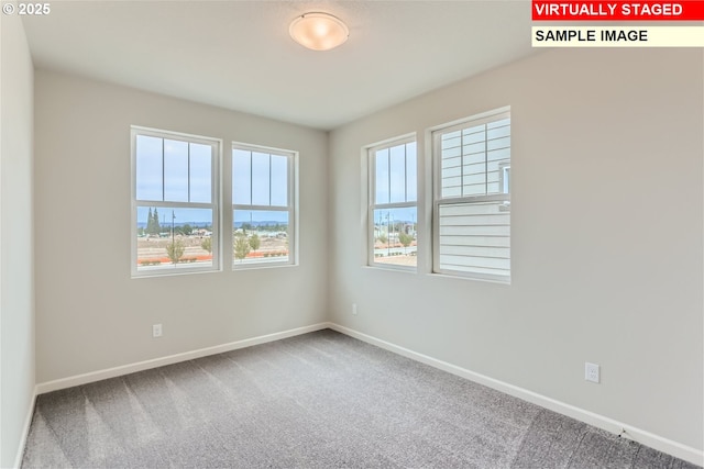 carpeted spare room featuring baseboards