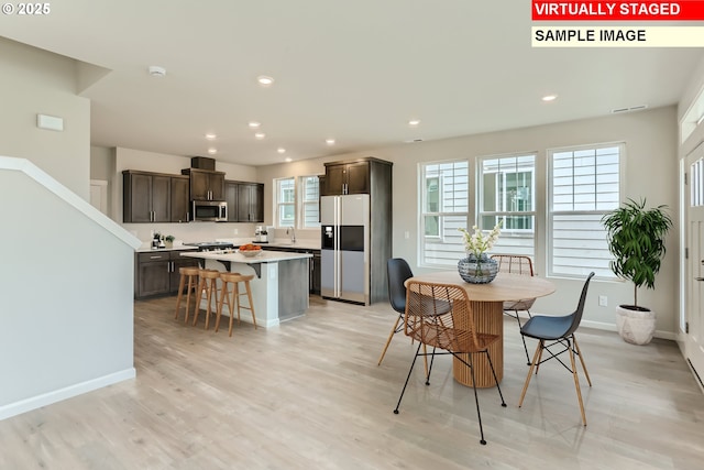 dining space with recessed lighting, baseboards, and light wood-style floors