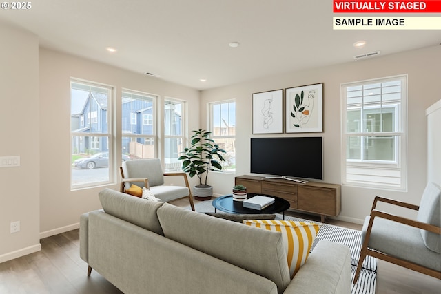 living room featuring visible vents, recessed lighting, baseboards, and wood finished floors