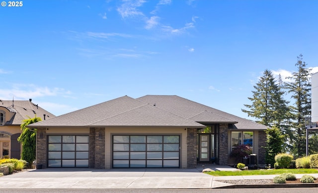prairie-style house featuring a garage, concrete driveway, and roof with shingles