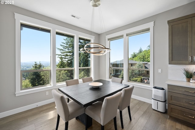 dining room featuring baseboards, plenty of natural light, light wood-style flooring, and visible vents