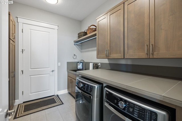 laundry room featuring baseboards, a sink, cabinet space, and independent washer and dryer