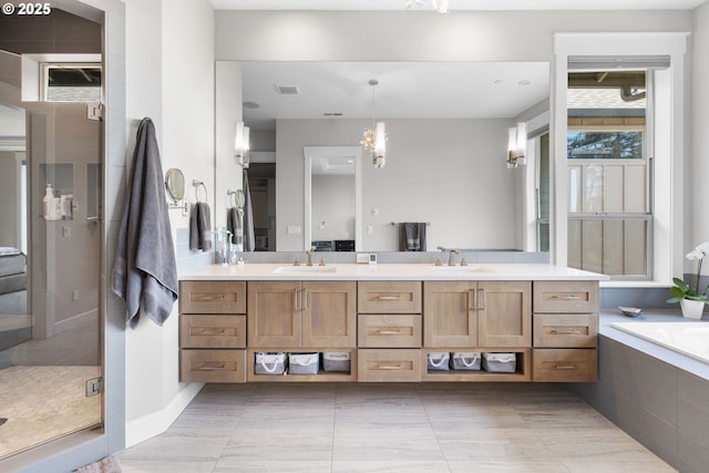 bathroom with a sink, a stall shower, double vanity, and visible vents