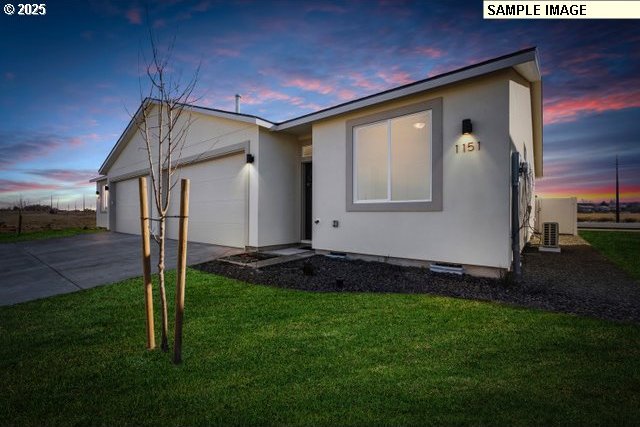 1197 NE Emerald Dr, Hermiston, OR 97838 - ranch-style home with a garage, concrete driveway, a front yard, and stucco siding