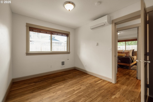9334 N Lombard St Unit 7, Portland, OR 97203 - empty room featuring a wall mounted air conditioner and light wood-style floors