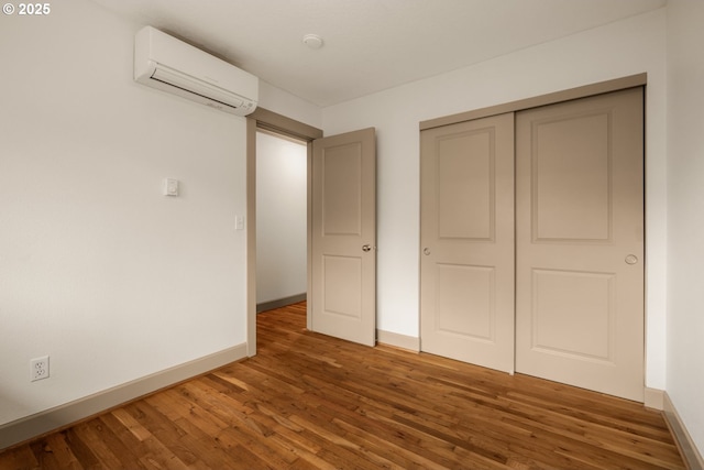 9334 N Lombard St Unit 7, Portland, OR 97203 - unfurnished bedroom with an AC wall unit, wood finished floors, and a closet