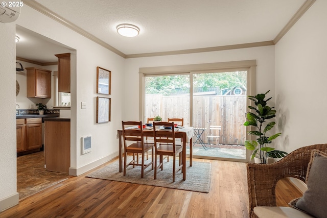 9334 N Lombard St Unit 7, Portland, OR 97203 - dining room with wood finished floors, ornamental molding, a wall mounted air conditioner, and heating unit