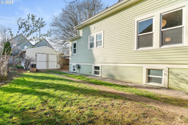 back of house with an outbuilding, a yard, a storage unit, and fence