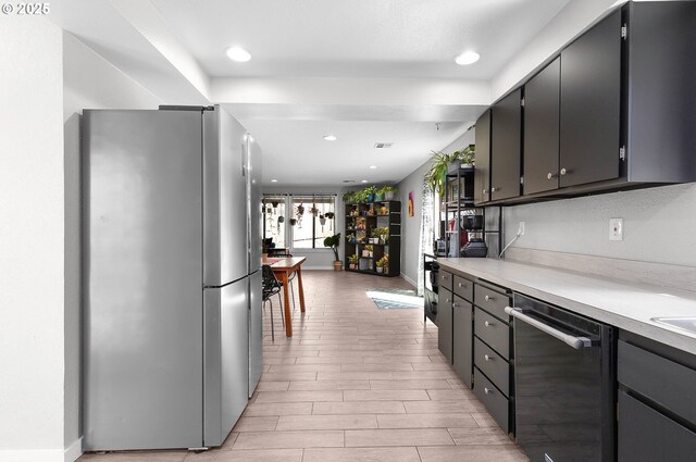 kitchen with freestanding refrigerator, recessed lighting, light countertops, light wood-style flooring, and dishwasher