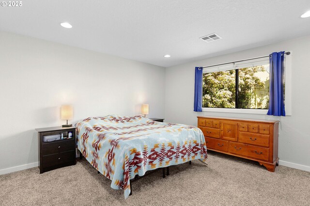 bedroom featuring baseboards, light colored carpet, recessed lighting, and visible vents