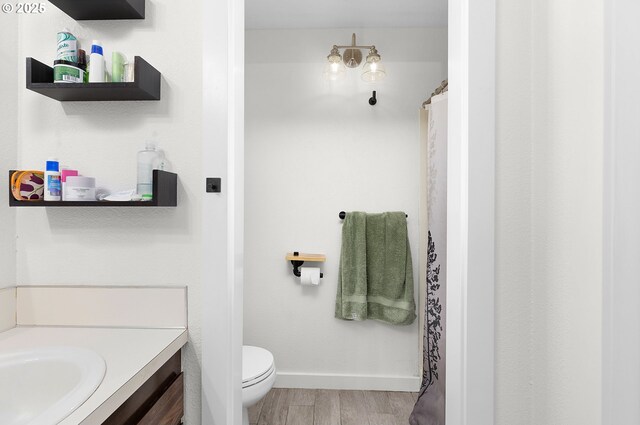 full bathroom featuring baseboards, vanity, toilet, and wood finished floors