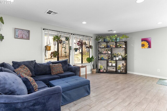 living room featuring light wood-style floors, recessed lighting, baseboards, and visible vents