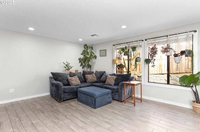 living area featuring light wood-type flooring, recessed lighting, and baseboards