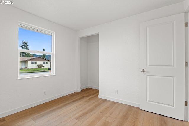 unfurnished room featuring light wood-style flooring and baseboards