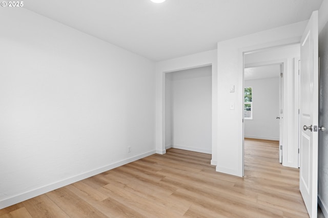 unfurnished bedroom featuring light wood-type flooring and baseboards