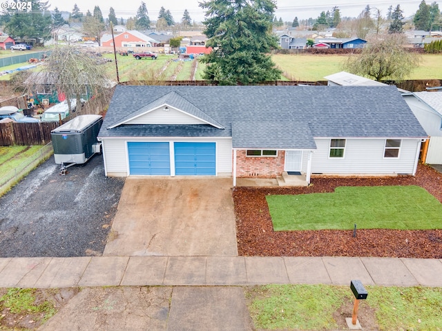 single story home with driveway, a garage, a shingled roof, a residential view, and a front yard