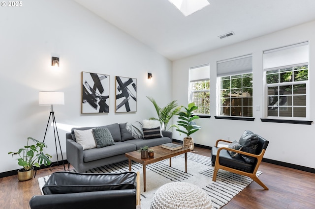 14426 SE Princeton Village Way, Clackamas, OR 97015 - living room featuring vaulted ceiling, baseboards, wood finished floors, and a skylight