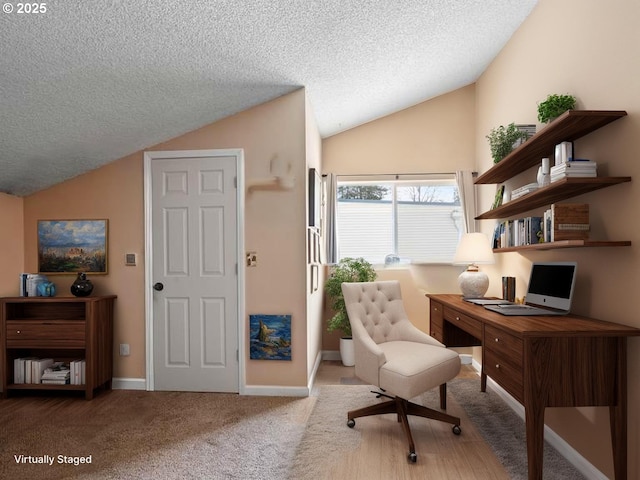 home office featuring lofted ceiling, a textured ceiling, carpet flooring, and baseboards