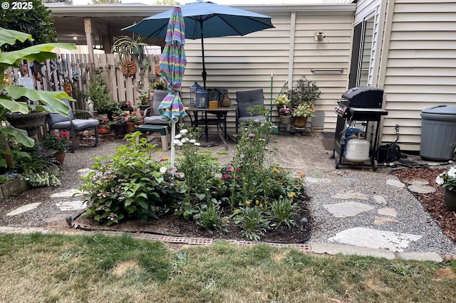 view of patio with fence and a grill