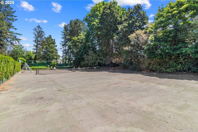 surrounding community featuring a tennis court and fence