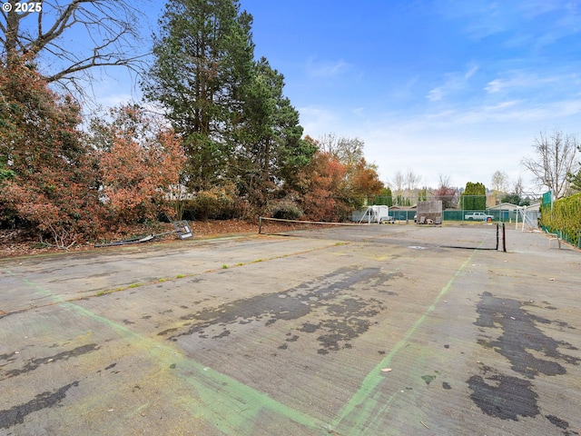view of yard featuring fence and a tennis court