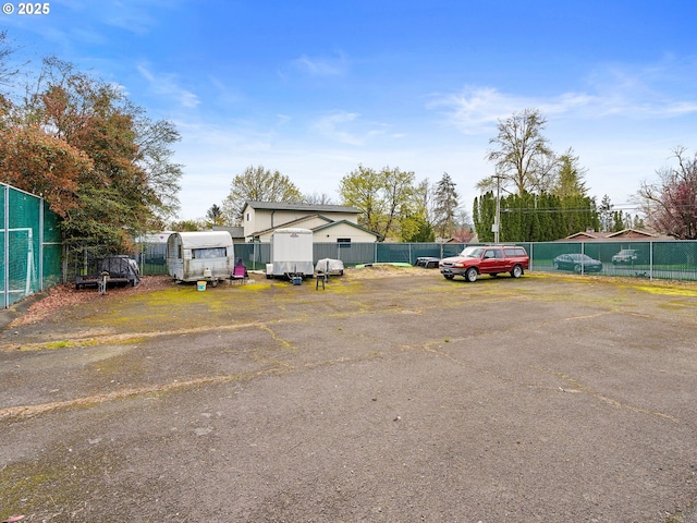 uncovered parking lot with fence and a shed