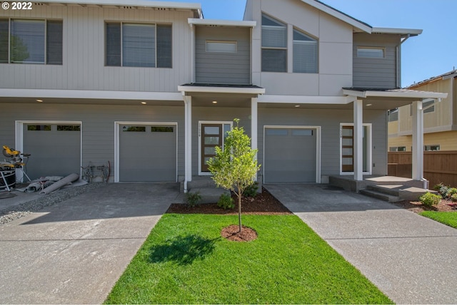 view of property featuring concrete driveway, an attached garage, and fence