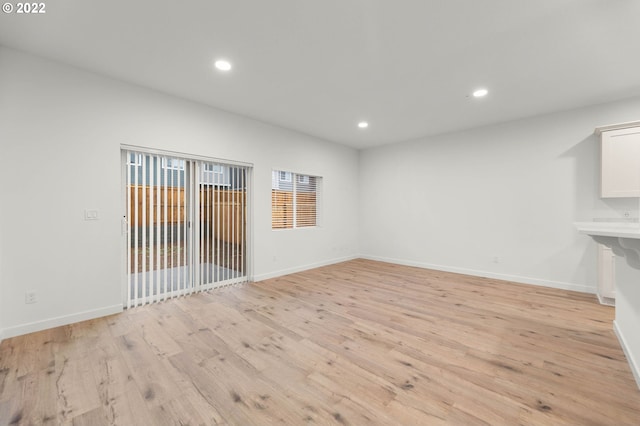 empty room featuring light wood-style floors, baseboards, and recessed lighting