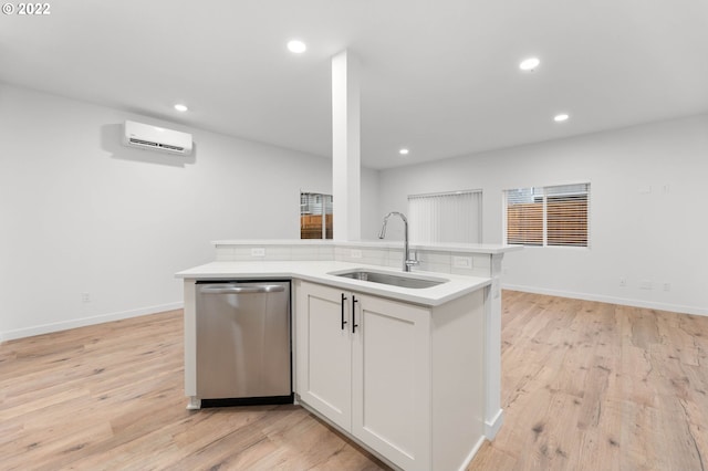 kitchen featuring stainless steel dishwasher, light wood-style floors, a wall mounted air conditioner, recessed lighting, and a sink