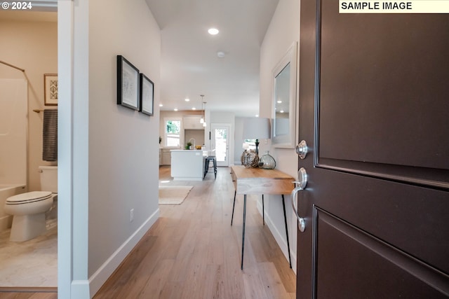 corridor featuring recessed lighting, baseboards, and light wood-style floors