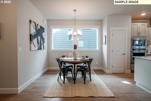 dining space with baseboards, recessed lighting, light wood finished floors, and a chandelier