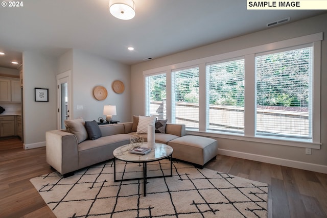 living room featuring baseboards, recessed lighting, light wood finished floors, and visible vents