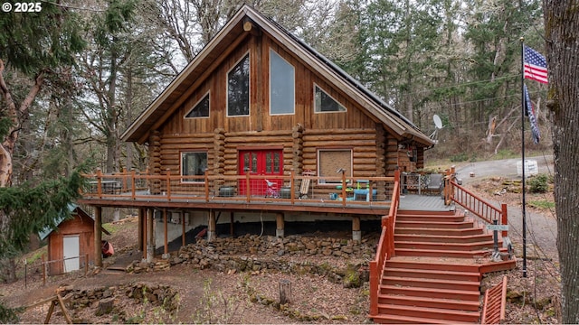 back of property with stairs, a deck, and log siding