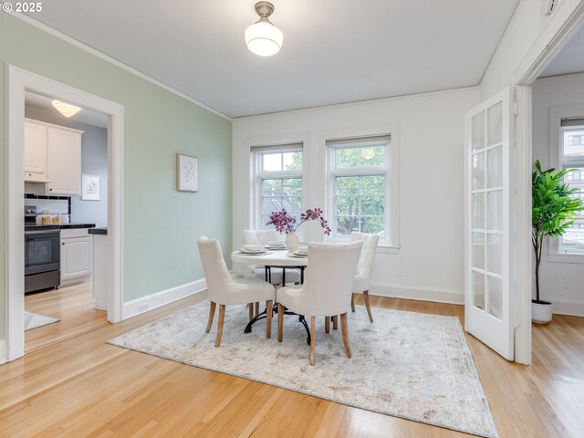 2015 NW Flanders St Unit 511, Portland, OR 97209 - dining area featuring light wood finished floors, crown molding, and baseboards