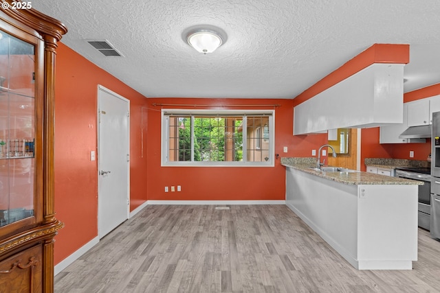 5715 SW 191st Ave, Beaverton, OR 97078 - kitchen with stainless steel electric stove, light wood-style floors, a peninsula, light stone countertops, and a textured ceiling