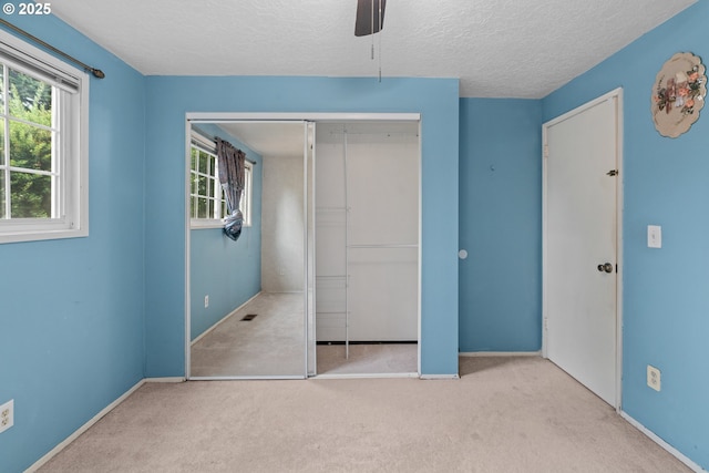 5715 SW 191st Ave, Beaverton, OR 97078 - unfurnished bedroom featuring multiple windows, a textured ceiling, carpet flooring, a closet, and a ceiling fan