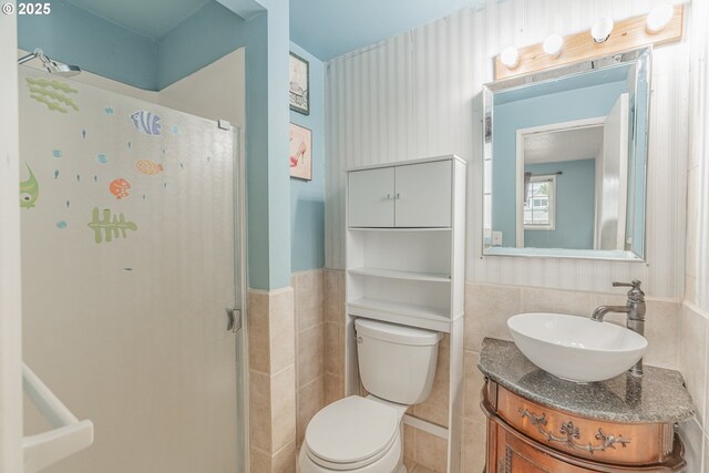 5715 SW 191st Ave, Beaverton, OR 97078 - bathroom featuring tile walls, a shower, a wainscoted wall, and vanity