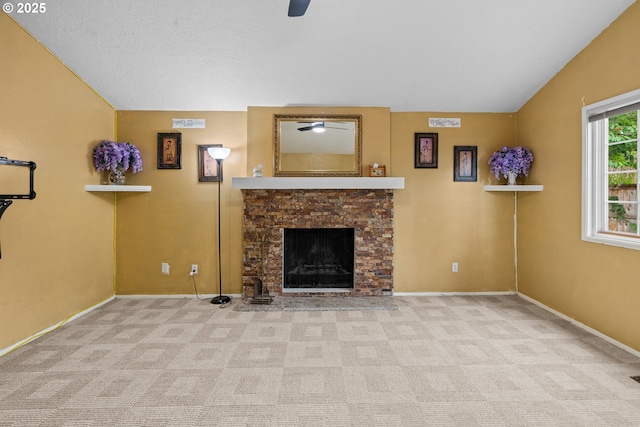 5715 SW 191st Ave, Beaverton, OR 97078 - unfurnished living room featuring a stone fireplace, carpet, vaulted ceiling, and a ceiling fan