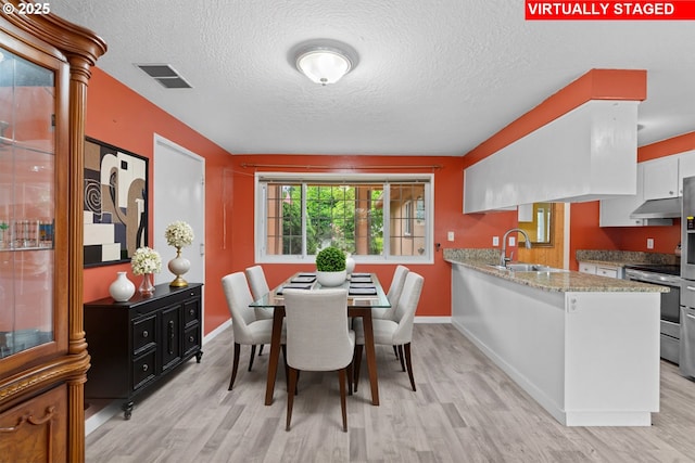 5715 SW 191st Ave, Beaverton, OR 97078 - dining space featuring light wood-style floors and a textured ceiling