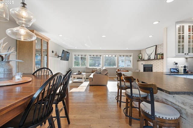 99 Walnut St, La Grande, OR 97850 - dining area featuring light wood-type flooring, a brick fireplace, and recessed lighting