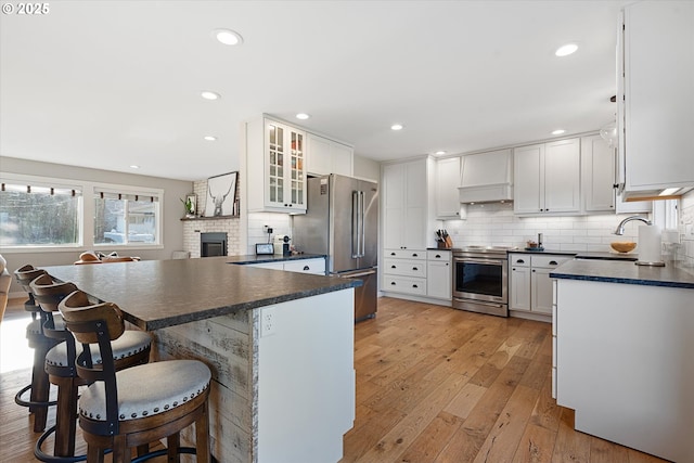 99 Walnut St, La Grande, OR 97850 - kitchen featuring appliances with stainless steel finishes, dark countertops, white cabinetry, light wood finished floors, and recessed lighting