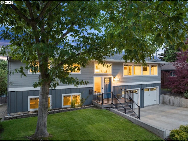 99 Walnut St, La Grande, OR 97850 - rear view of property with driveway, a yard, an attached garage, and board and batten siding