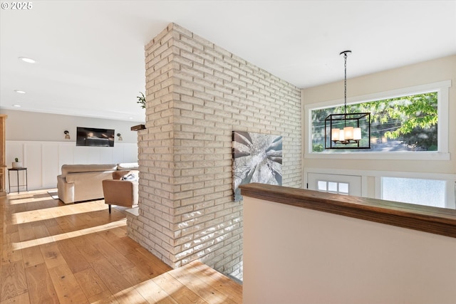 99 Walnut St, La Grande, OR 97850 - hallway featuring hardwood / wood-style floors, a chandelier, brick wall, and recessed lighting