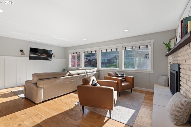 99 Walnut St, La Grande, OR 97850 - living room with plenty of natural light, light wood-type flooring, a fireplace with raised hearth, wainscoting, and recessed lighting